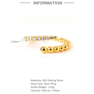 Macro shot of S925 sterling silver open ring with gold beads and sparkling zircon details