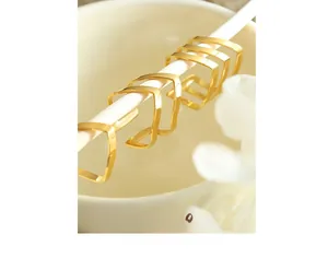 Detailed close-up of a 6-piece set of gold V-shaped geometric rings on white stands