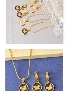 Detail view of butterfly necklace and earrings set with black and white shell pendants