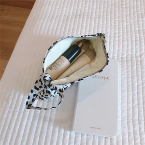 Detail of dalmatian print canvas pouch with smooth zipper and makeup brushes inside
