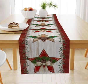Detail of Christmas linen table runner with vintage wood grain, red stars and pine cones