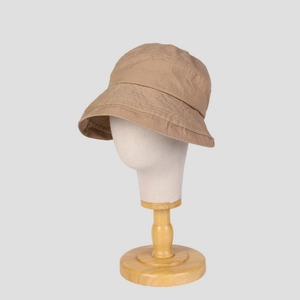 Detail view of khaki cotton bucket hat with textured fabric and rolled edge on a head form