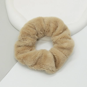 Détail macro du chouchou en peluche imitation fourrure de lapin kaki sur plateau blanc