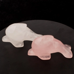 Handcrafted natural pink quartz and clear crystal dolphin figurines on a black base