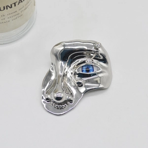 Artistic surrealist silver metal face brooch with blue eye and sparkling crystal details