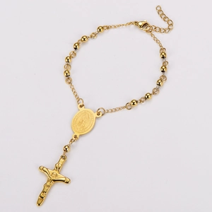 Detail of 18k gold plated beaded bracelet with cross pendant and virgin mary medal