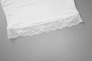Détail de l'ourlet en tricot blanc avec bordure en dentelle délicate sur le caraco