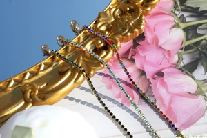 Detailed view of colorful rhinestone bracelets hanging on a vintage gold frame with roses