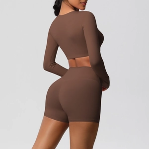 Side-rear view of tight dark brown yoga set featuring long sleeve crop top and high waist shorts
