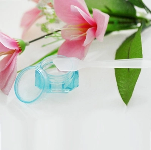 Transparent blue cosmetic jar with frosted spatula and pink floral decoration