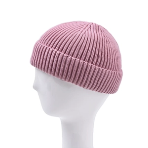 Primo piano di un berretto docker in maglia a coste rosa su una testa di manichino bianca.