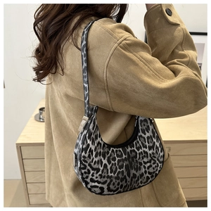 Leopard print crescent armpit bag with black strap shown styled on model in camel coat
