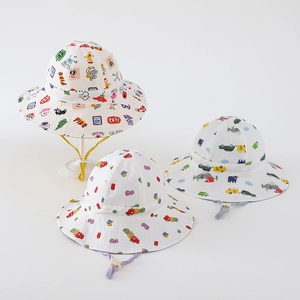 Detailed view of kids cartoon sun hats featuring car and block prints with windproof ropes