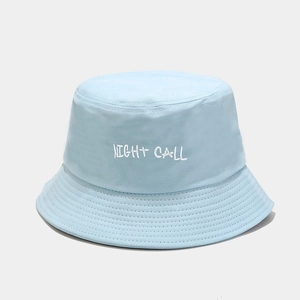 Detail of light blue bucket hat featuring white Night Call embroidery and cotton canvas texture