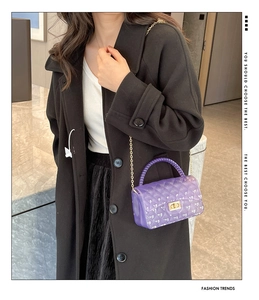 Detail of purple quilted jelly bag with gold metal chain worn by a fashion model