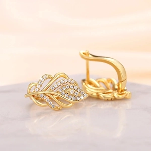 Macro shot of gold wheat ear earrings featuring white cubic zirconia leaf detailing