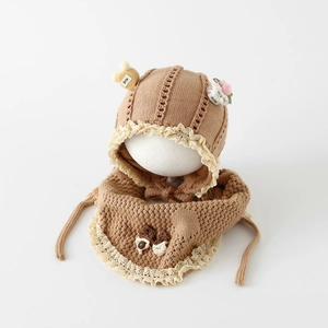 Detalle de conjunto de gorro y bufanda de punto para bebé con bordes de encaje