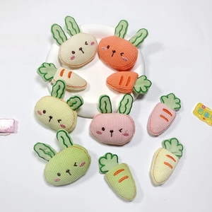Macro detail of corduroy plush rabbit and carrot DIY accessories in pastel colors