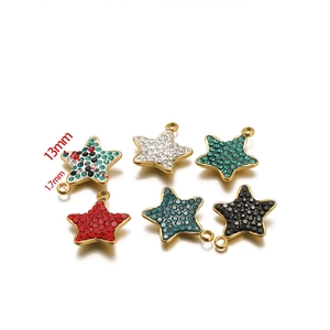 Macro detail of 13mm gold star charms with colorful rhinestones for DIY jewelry making