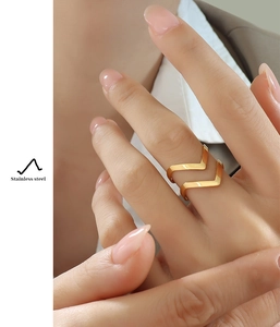 Close-up of double V-shaped rose gold stainless steel ring worn on model's finger