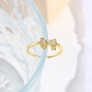 18k gold plated adjustable ring with a delicate bow design and cubic zirconia accents