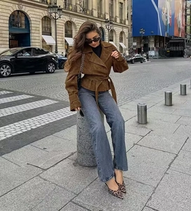 Short faux suede jacket with notched collar and waist tie on an urban street background