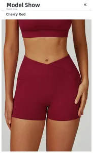 Detail of high-waisted yoga shorts in cherry red with cross-waist design and side pockets