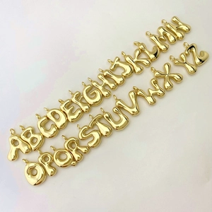 Full set of golden 26 alphabet balloon pendants with glossy metallic finish on white background