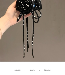 Detail of fabric flower hair claw with black and white polka dot patterns