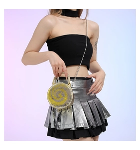 Detail of silver round handbag with yellow spiral pattern and metallic chain strap