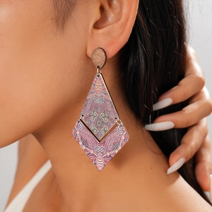 Close-up of bohemian wooden geometric diamond earrings with vintage ethnic patterns on model