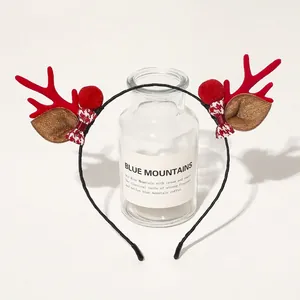 Detail of Christmas headband with red reindeer antlers and plaid bow on display