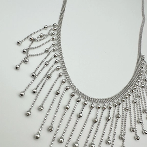Minimalist silver fringe tassel necklace with polished metal beads on white background