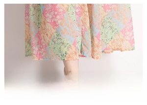 Detailed close-up of the flowing loose hem on a colorful ethnic floral print maxi dress