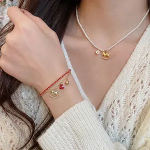 Elegant pearl necklace and woven red bracelet set with golden rocking horse charm on a model