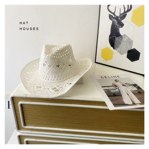 Macro detail of white openwork crochet patterns on a stylish western straw cowboy hat