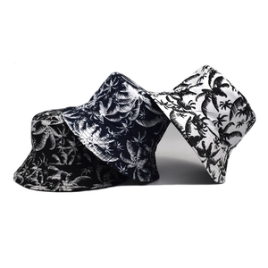 Close-up of tropical coconut tree print on reversible cotton bucket hats in black and white