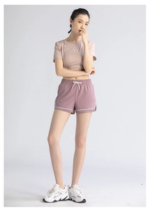 Detail of pink two-piece sports set with drawstring shorts and white piping trim