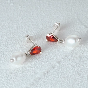 Close-up of S925 sterling silver drop earrings with red ruby zircon and white pearl