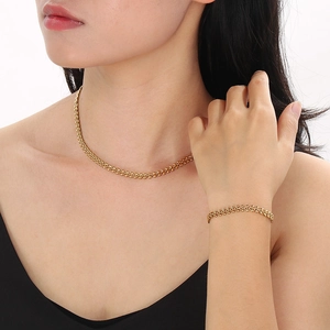 Elegant gold titanium steel wheat chain necklace and bracelet set worn by a female model