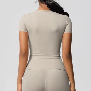 Haut de yoga beige ajusté en tissu élastique à séchage rapide, vue de dos du modèle