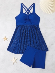 Detail of dark blue tankini set with lace skirt and flat swim shorts on marble surface