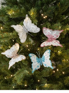 Detailaufnahme der glitzernden Schmetterlingsanhänger in vier Farben am Weihnachtsbaum