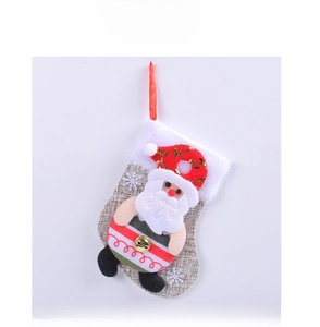 Detail of Christmas stocking featuring 3D Santa plush, linen texture, and gold bell