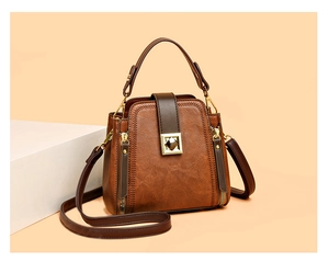Detailed view of brown leather bucket bag with gold square lock and lychee texture finish