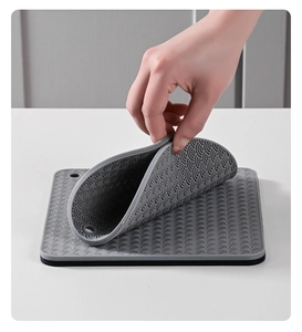Close-up of grey silicone heat-resistant mat with anti-slip ripple texture and flexible design