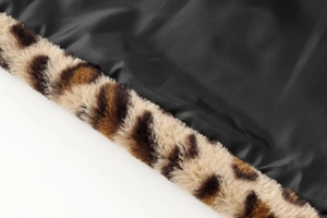 Detailed macro view of leopard print faux fur trim and black inner lining of the coat