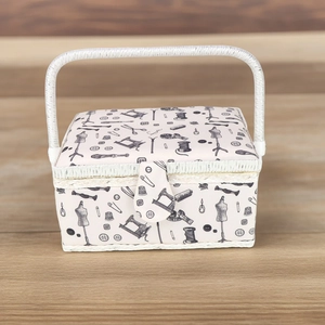 Detail of fabric sewing basket with vintage machine prints on a light wooden table