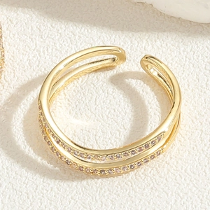 Close-up of gold plated multi-layer ring with sparkling zircon stones and open design