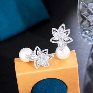 Detailed macro shot of elegant pearl flower earrings with zircons on a gift box